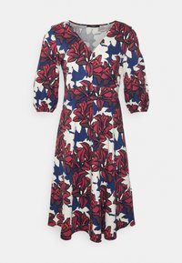 Vestido floral con fondo azul marino y patrones en rojo y blanco, escote en V y mangas de tres cuartos tipo globo. Confeccionado en tela ligera.