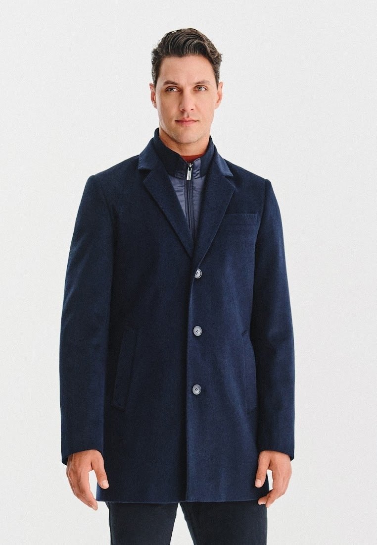 Granatowy płaszcz wełniany w mieszance z elegancką strukturą, z klapami w kształcie notcha, zapięciem na guziki i kieszeniami po bokach. Gładka faktura z dopasowanym krojem.