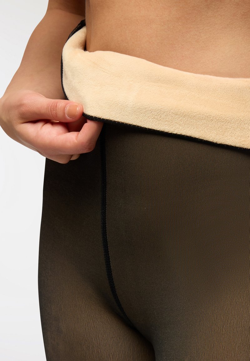 Czarne rajstopy z miękkim beżowym pasem z polaru. Teksturowany materiał charakteryzuje się pionowymi paskami oraz płaskimi szwami na krawędziach.