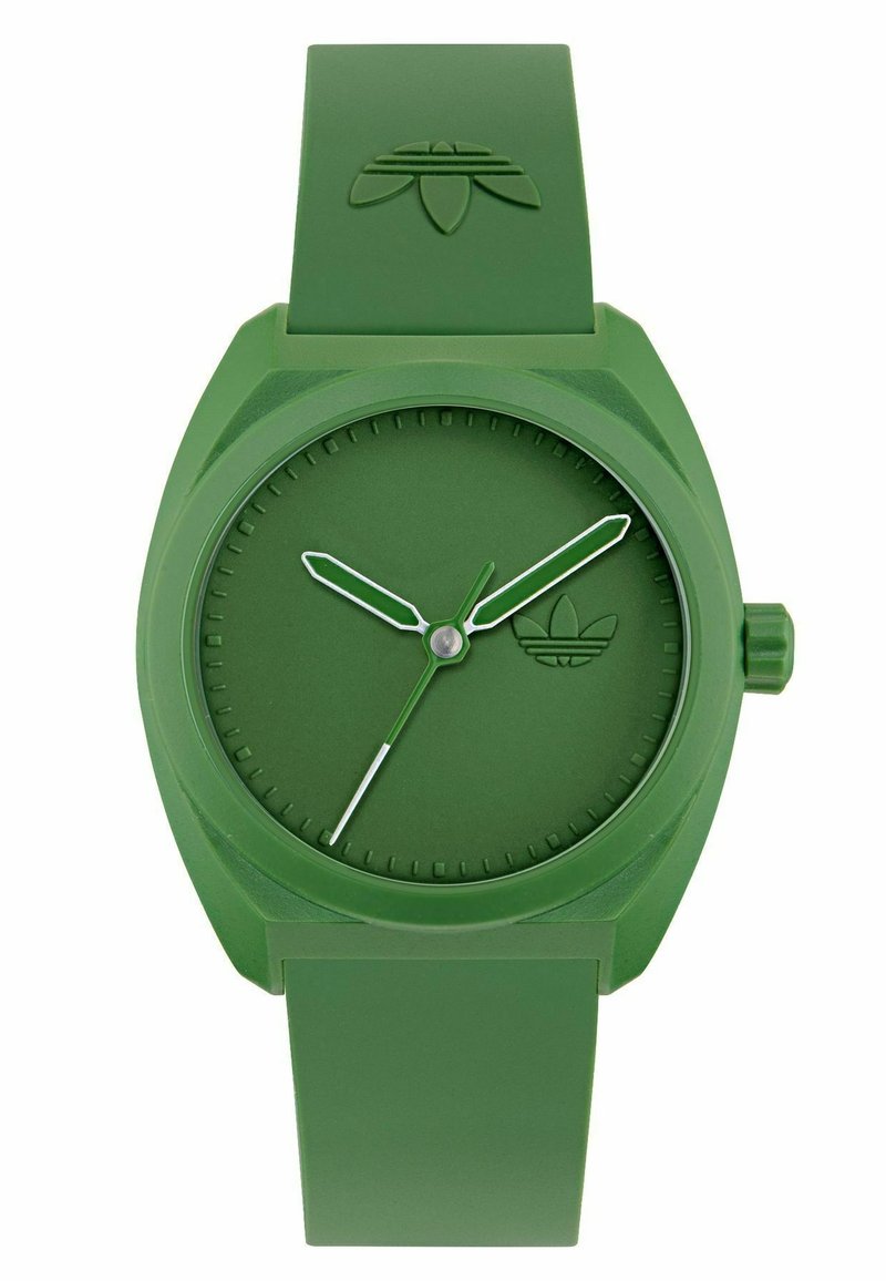 Žalias silikono laikrodis su matinio paviršiaus apdaila, apvaliu ciferblatu, baltais valandų žymekliais, žaliais rodyklėmis ir iškeltu logotipu ant dirželio.