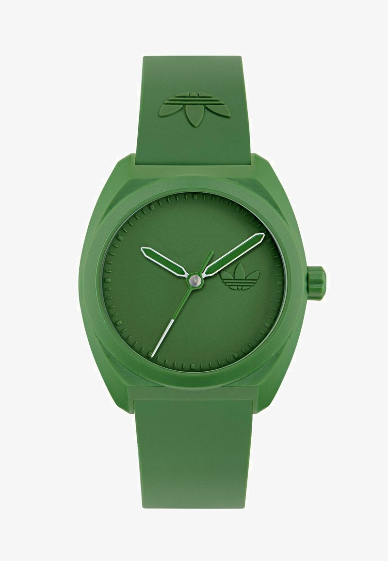 Žalias silikono laikrodis su matinio paviršiaus apdaila, apvaliu ciferblatu, baltais valandų žymekliais, žaliais rodyklėmis ir iškeltu logotipu ant dirželio.