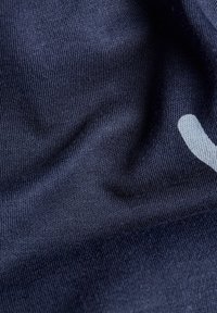 Tejido azul marino con una textura suave, que presenta una ligera elasticidad y un elemento de diseño curvado en blanco en la superficie.