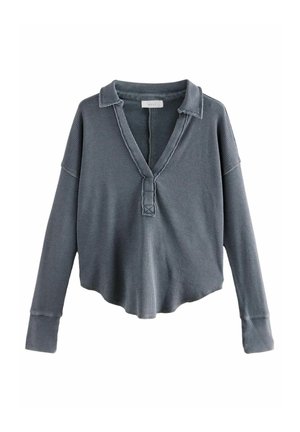 Chemise en tricot gaufré gris foncé à manches longues avec un profond col en V et un col, avec des poignets allongés et un ourlet ample et arrondi.