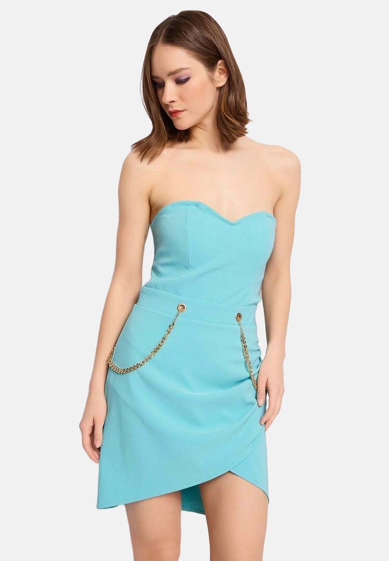 Abito aderente senza spalline di colore azzurro chiaro, con scollatura a cuore, orlo asimmetrico e dettagli in catena dorata sui lati.