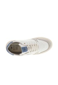 Sneaker in pelle bianca con un accento in denim blu sulla linguetta, punta perforata e suola in gomma a contrasto. I lacci sono bianchi e ben visibili.