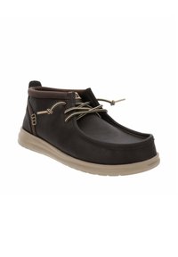 Scarpe in pelle nera con design a basso taglio e punta tondeggiante. Presentano suola in gomma di colore chiaro e lacci bicolore. Accenti in gomma ai lati.