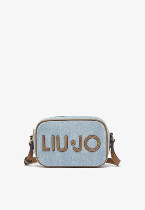 Sac bandoulière en denim bleu clair avec garniture en cuir marron et bandoulière ajustable, présentant de grandes lettres "LIU JO" cousues sur le devant.