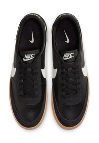 Zapatillas deportivas de cuero negro con acabado suave, logo en forma de swoosh en blanco, cordones negros y suela de goma. El diseño incluye puntera y talón reforzados.