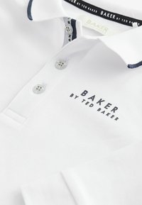Witte polo shirt van textuurstof met een marineblauwe rand op de kraag, een drieknoopsluiting en het "BAKER by TED BAKER" logo in het zwart.