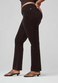 Braune, taillierte Hose mit geradem Bein. Hergestellt aus weichem Material, mit dezenten Nähten und einer klassischen Taschenanordnung.