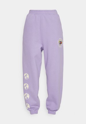 Lila Jogginghose mit einem elastischen Bund, ausgestattet mit seitlichen Taschen, einem kreisförmigen Logo an der Hüfte und vier Globus-Designs entlang des linken Beins.