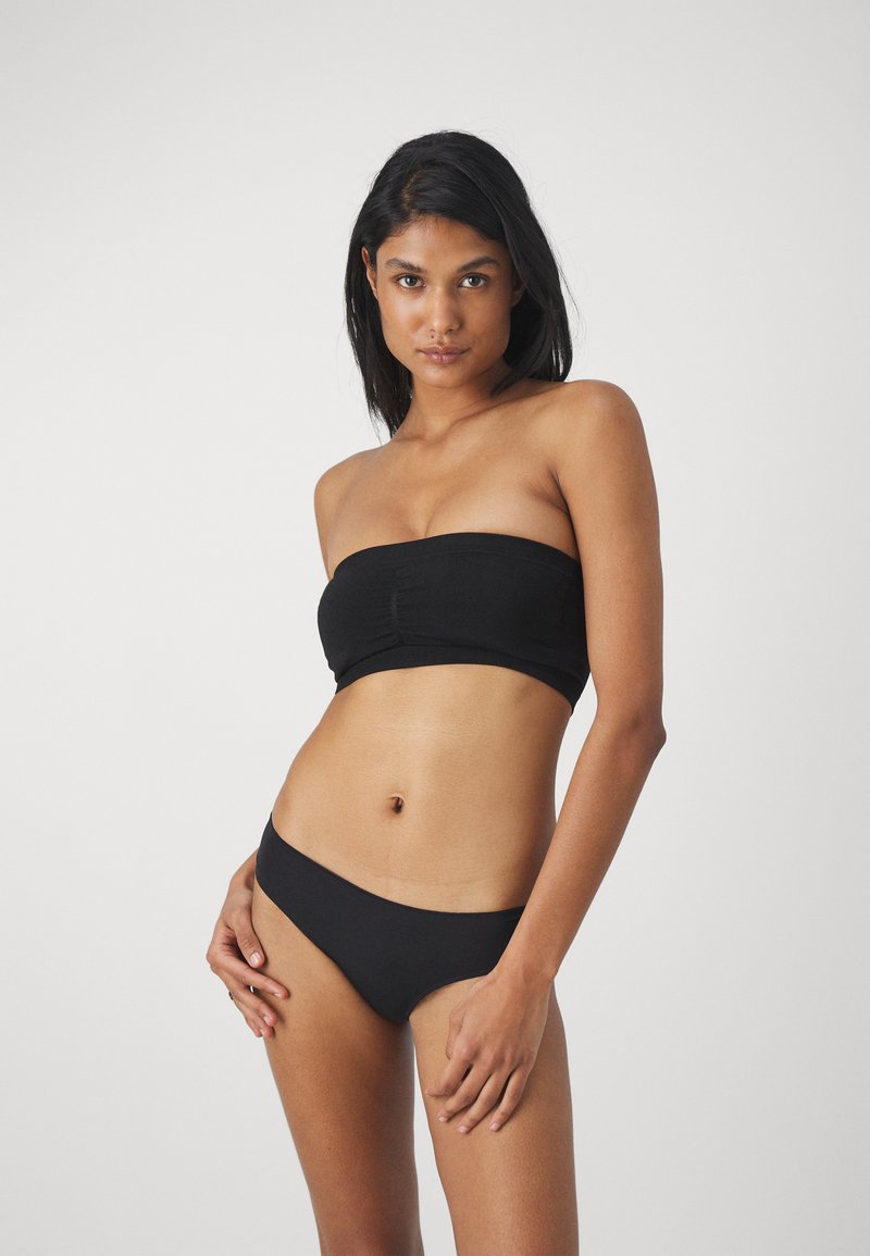 Čierny bandeau bikinový top s zhromaždeným stredovým švom; zodpovedajúce nízko pásové bikinové nohavičky; hladká textúra; priliehavý dizajn.