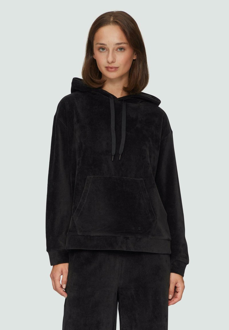 Zwarte corduroy hoodie met een buidelzak, trekkoordcapuchon en geribbelde manchetten. Zachte textuur, ontspannen pasvorm en subtiele merkaanduiding.