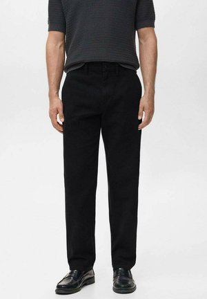 Pantaloni in denim nero con taglio dritto, materiale leggero e texture sottile. Abbinati a mocassini neri.