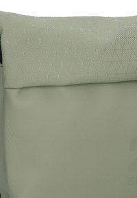 Borsa verde chiaro con una parte superiore trapuntata e texture quadrata che presenta un motivo a rombi e un corpo liscio; realizzata in materiale resistente e impermeabile.