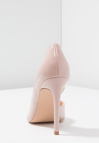 Patentní růžová lodička s špičatou špičkou, elegantním siluetou a jehlovým podpatkem. Hladký povrch s minimálním zdobením.