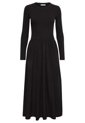 Robe noire à manches longues avec un corsage côtelé et une jupe fluide et froncée. Elle présente un col rond et une longueur mi-mollet.