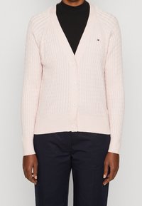 Helle rosa gestrickte Jacke mit V-Ausschnitt, strukturiertem Muster und sechs Knöpfen vorne. Gerippte Säume und Bündchen mit Logodetails.