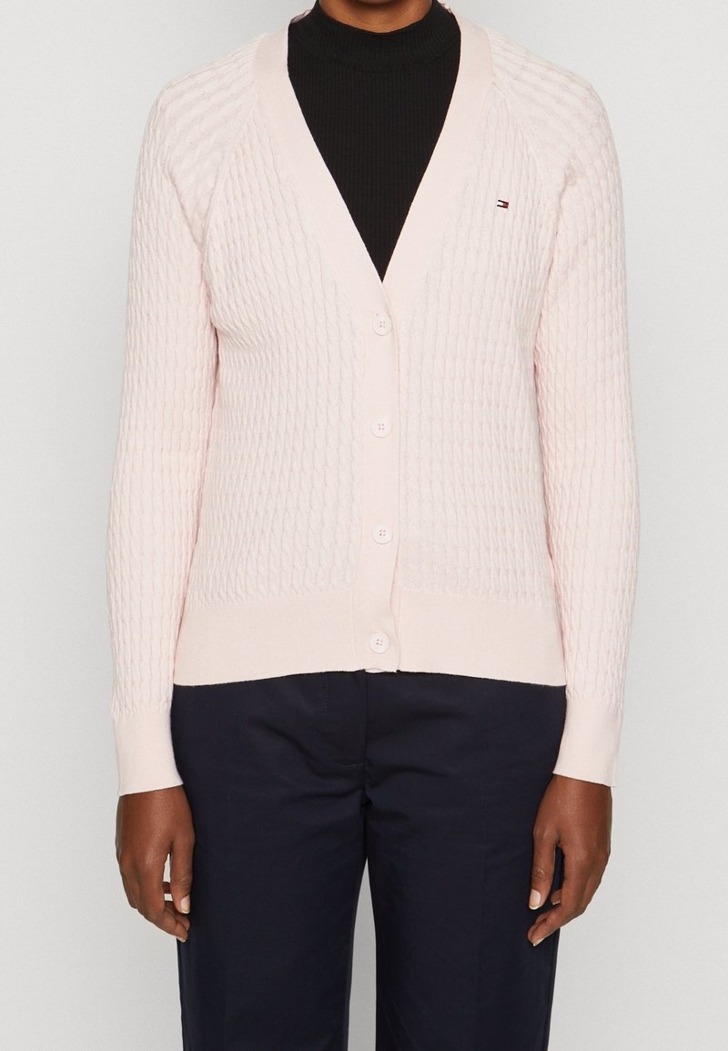Helle rosa gestrickte Jacke mit V-Ausschnitt, strukturiertem Muster und sechs Knöpfen vorne. Gerippte Säume und Bündchen mit Logodetails.