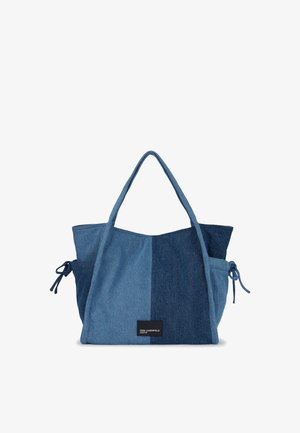 Blå lappet denim tote bag med to håndtak, sidesløyfer og en liten svart label som sier "KARL LAGERFELD JEANS" foran.