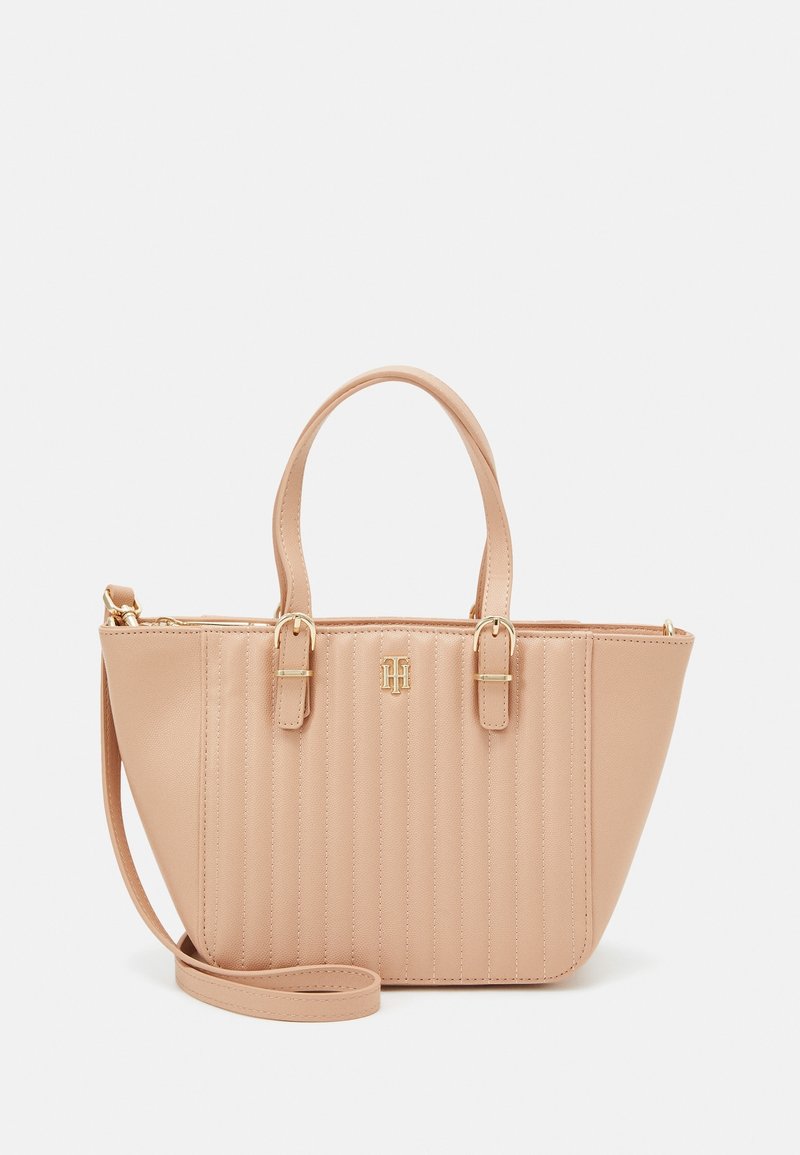 Sac cabas en cuir beige avec couture verticale, deux poignées, une bandoulière amovible et une quincaillerie dorée avec un petit logo.