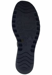 Black rubber shoe sole with a textured pattern, featuring grooves and embossed "FLY LONDON" branding, designed for grip and durability.