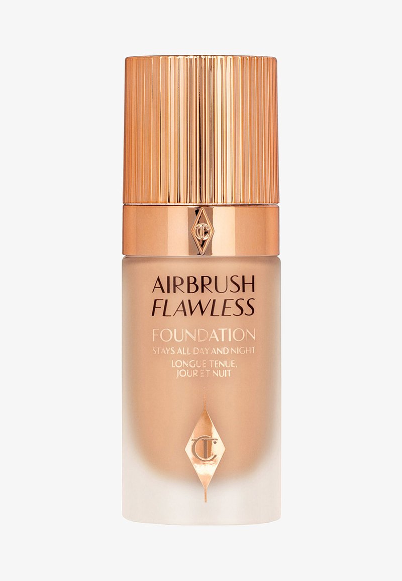 Foundation-Flasche mit einem dicken, matten Glasfuß und einem metallischen Goldverschluss, der vertikale Rillen und ein diamantförmiges Logo aufweist.