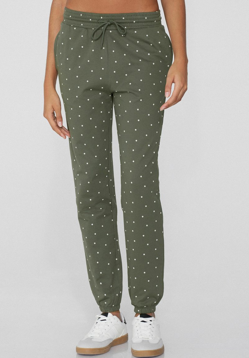 Pantalones jogger verde oliva con lunares blancos, cintura elástica, cordón y puños elásticos; tejido suave con una textura lisa.