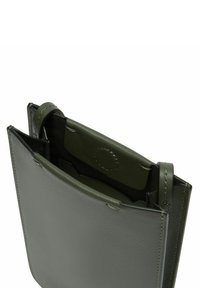 Zielono-oliwkowa skórzana torebka o gładkiej fakturze, z otwartą górą, wewnętrzną kieszenią i mocnymi bocznymi paskami.