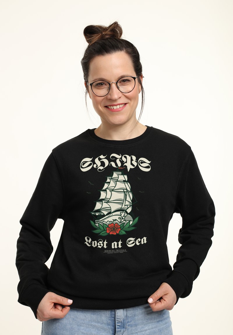 Felpa nera con grafica di una nave e il testo "NAVI Perse in Mare" con un design di rosa. Collo e polsini a costine, vestibilità casual.