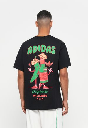 Black cotton t-shirt featuring a colorful graphic of a jalapeño and a bottle, with the text "ADIDAS Originals Hot Jalapeño" in bold font.