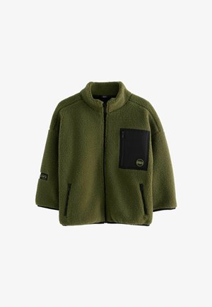 Veste en polaire olive avec fermeture éclair sur le devant, col haut et poche en patch noire. Elle présente une coupe ample et des accents noirs contrastants.