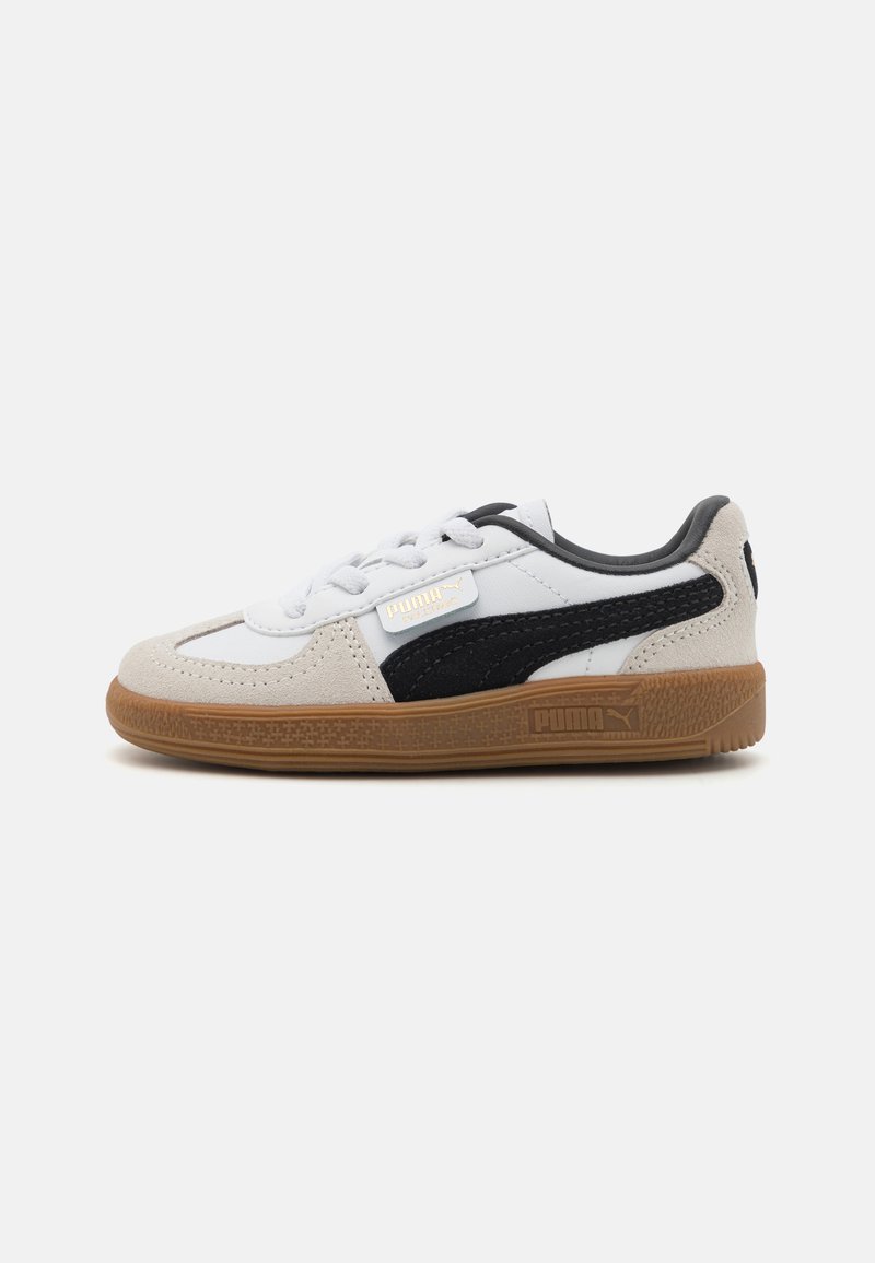 Hvite og svarte sneakers med overdel av semsket skinn og lær, med såle av gummigummi, snøring og gulllogo detaljer.