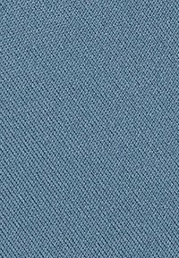 Tela azul texturizada con un fino patrón tejido. El material parece duradero y bien entrelazado, con un sutil brillo y líneas diagonales.