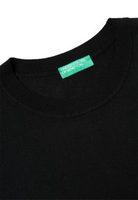 Černý svetr s žebrovaným kulatým výstřihem. Vyroben z měkké látky. Obsahuje zelenou nálepku s nápisem "United Colors of Benetton."