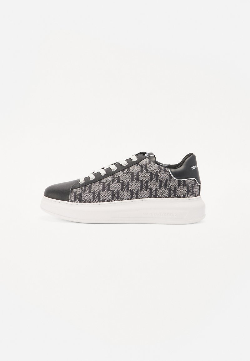 Sneaker neri e grigi con motivo, suola bianca, caratterizzati da una tomaia testurizzata, inserti in pelle nera e un sistema di allacciatura tradizionale.