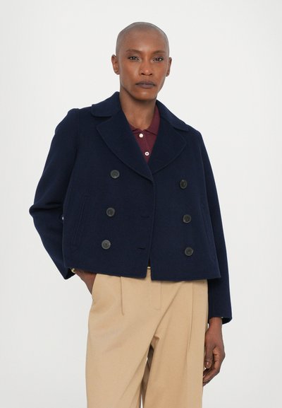 Cappotto doppiopetto in blu navy con grandi bottoni neri, ampi revers e un design accorciato, realizzato in un tessuto di lana testurizzata.