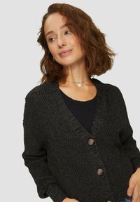 Dunkles, gestricktes Cardigan mit V-Ausschnitt, langen Ärmeln und zwei Knöpfen vorne. Die Textur ist dick und die Farbe ist ein tiefes Anthrazitgrau.