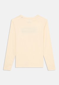 Langermet, lys beige t-skjorte laget av myk stoff, med klassisk rund hals og enkelt design uten synlige mønstre eller detaljer.