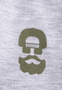 Gray fabric featuring an olive green printed graphic of a skull wearing a hat with a mustache, positioned centrally on the material.