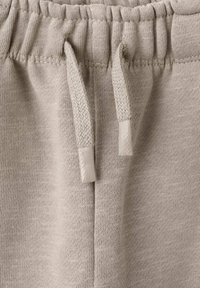 Beige tepláky se šňůrkou vyrobené z texturované látky, s nařaseným pasem a plochými šňůrkami s tkaným detailem.