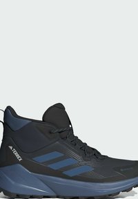 Botín de senderismo negro y azul con parte superior texturizada, forro GORE-TEX, punta reforzada y tres franjas azules en el lateral. Diseño de suela resistente.