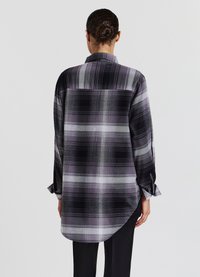 Camicia a maniche lunghe a quadri in tonalità di nero, grigio e viola. Presenta un colletto, orlo curvo e polsini con bottoni. Tessuto texture.