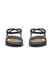 Schwarze flache Sandalen verfügen über mehrere überkreuzte Riemen, eine glatte Lederoberfläche und eine braune Innensohle mit einer Naht entlang der Kante.