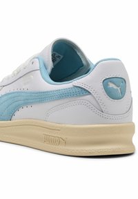 Sneaker bianco con accenti azzurri chiaro, caratterizzata da una striscia in suede testurizzato, una suola in gomma di colore crema e un logo sottile sul tallone.