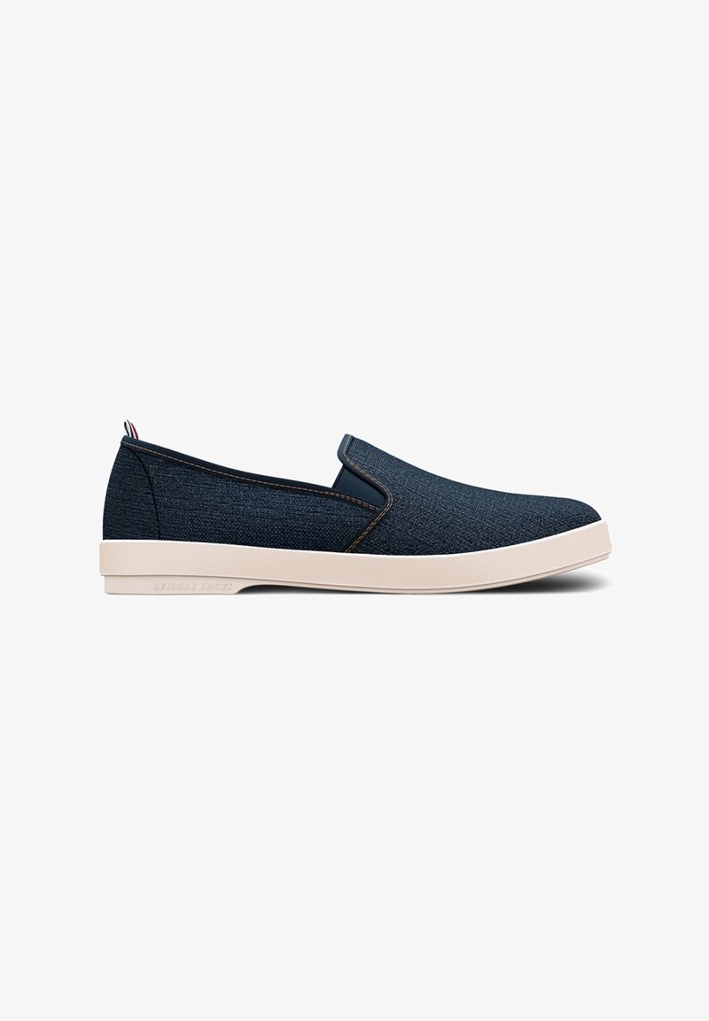 Slip-on sko med overdel i marineblå denim, kontrasterende beige gummisål, elastiske sidedetaljer og lette syninger.