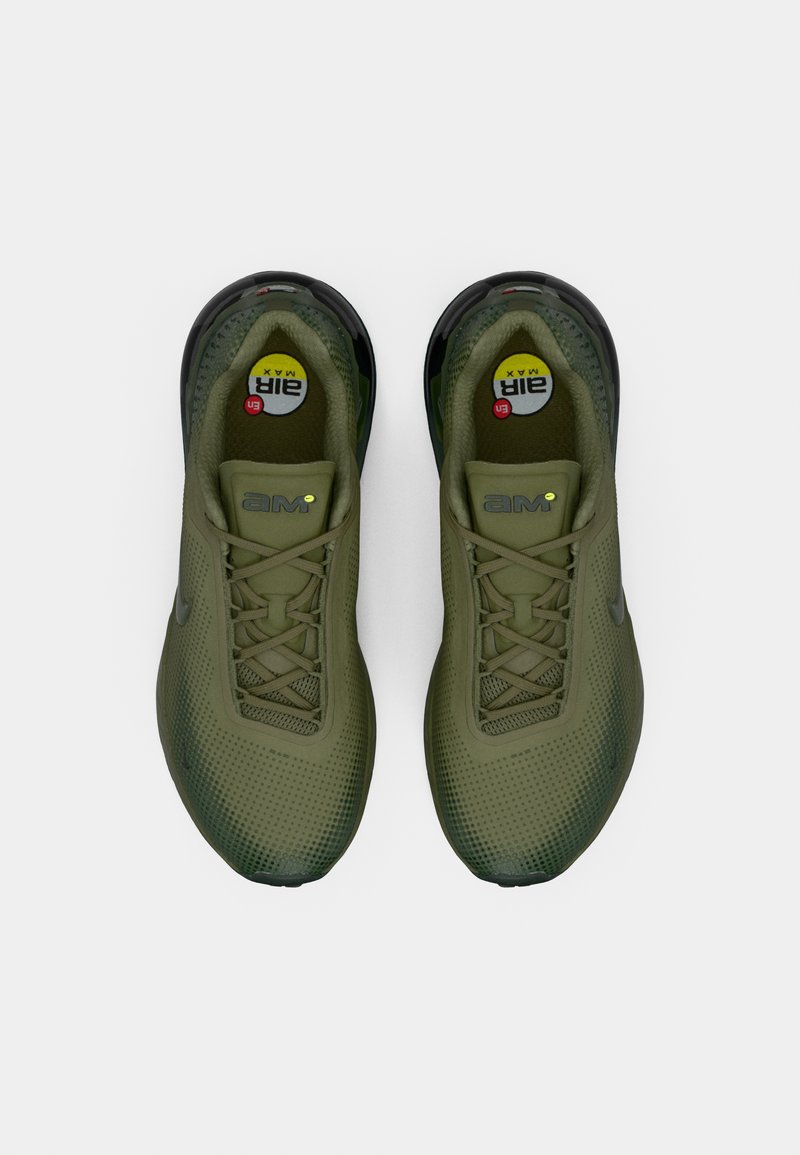 Olive green sports shoes with a mesh upper, rounded toe, textured surface, and visible air cushioning in a black sole. Laces are braided.