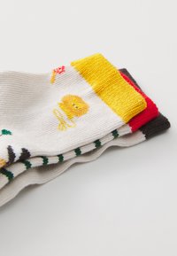Calzini di cotone multicolori con accenti gialli, rossi e grigi. Presentano disegni giocosi che includono un personaggio e motivi floreali.