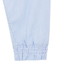 Tissu en coton rayé bleu et blanc avec des poignets élastiques froncés. Présente une texture légère et des rayures fines alternées.