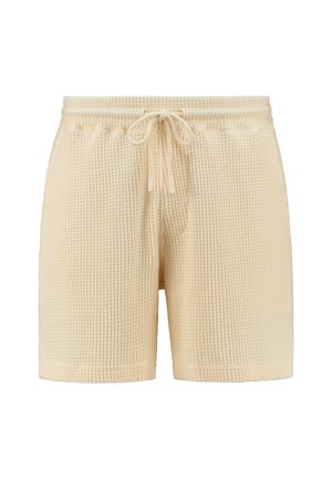 Beige színű, váffel kötésű rövidnadrág, elasztikus derékpánttal, zsinóros záródással és laza szabással. Egyszerű dizájn, minták vagy további díszítések nélkül.